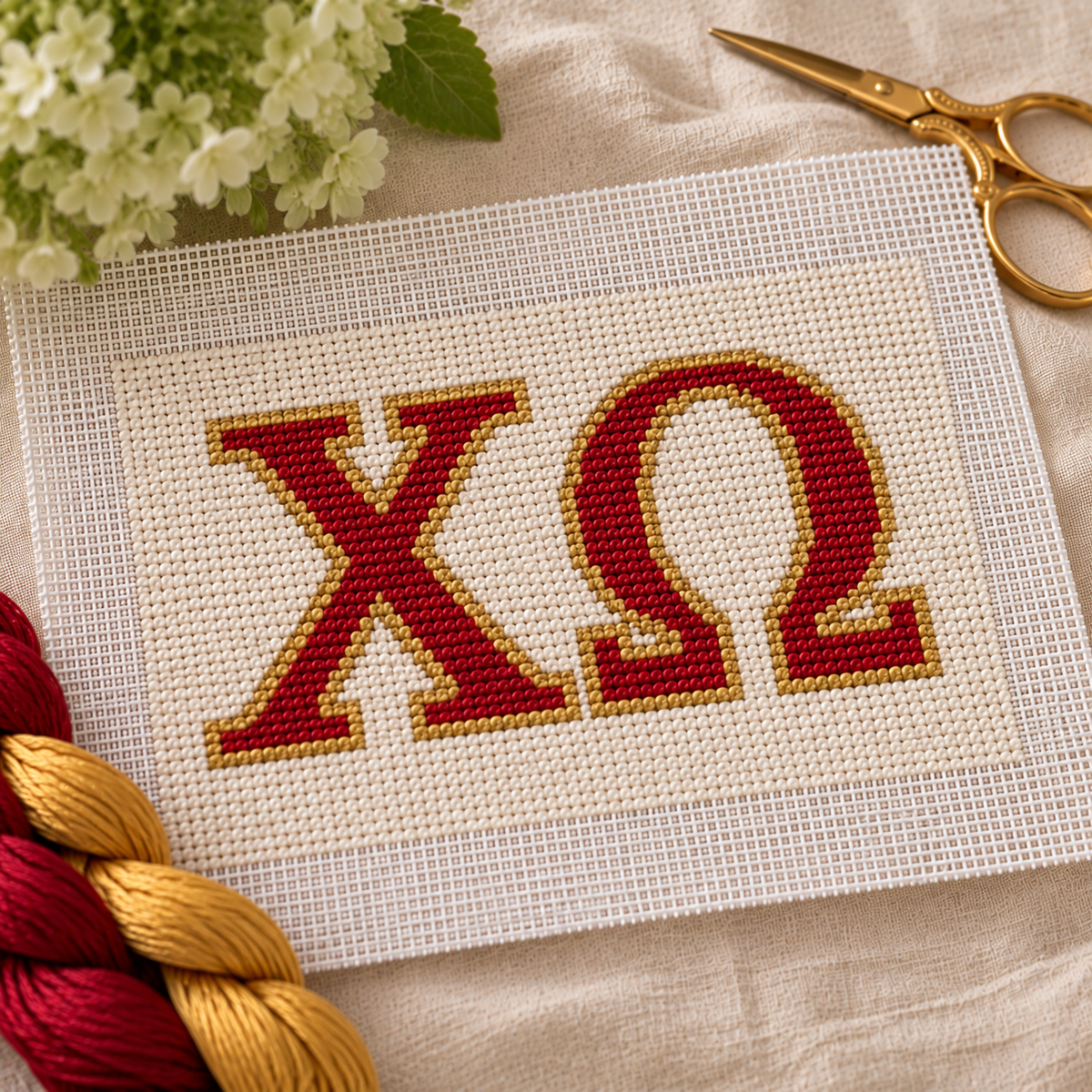Chi Omega needlepoint canvas with ΧΩ letters and gold crescent moon motif over cardinal red and cream stripes